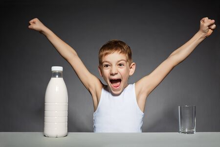 Happy boy with bottle of milkの写真素材