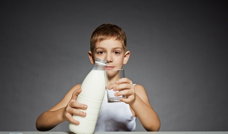Boy with milk bottle and glassの写真素材