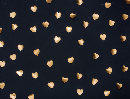 Gold heart stickers on dark textured backgroundの写真素材