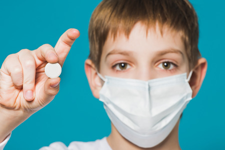 Boy protection mask holding big white pillの写真素材