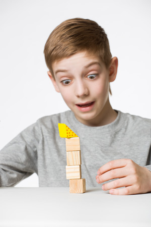 Portrait of a boy watching house made of wooden blocks fallの写真素材