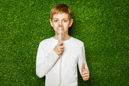 Boy breathing through inhalator mask thumb upの写真素材