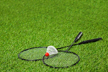 Crossed badminton rackets with shuttlecock over it