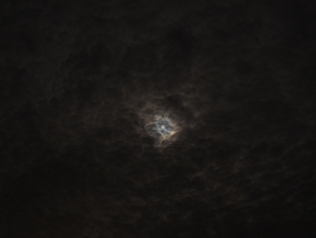 Moon seen through a thin layer of strange looking cloudsの写真素材