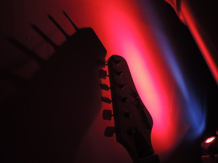 Guitar neck ending with colorful ambient lights in the backgroundの写真素材