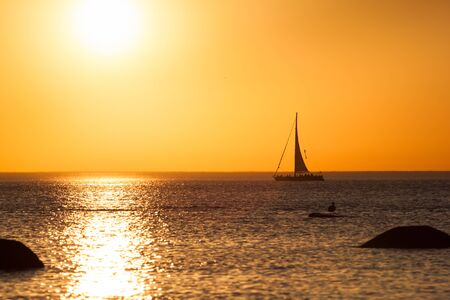 Photo of a yacht silhouette during sunsetの写真素材
