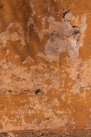 Cracked orange painted wall texture background materialの写真素材