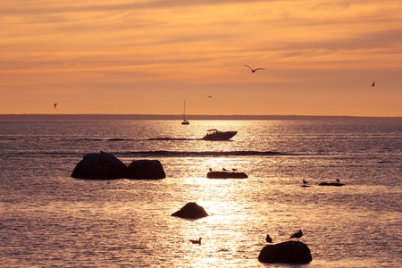 Yacht and boat silhouette in sea close to sunsetの写真素材