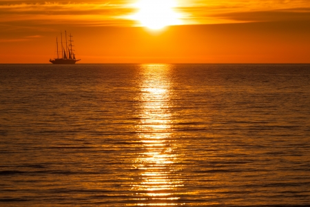 Sail ship silhouette at sea and sun sunsetの写真素材