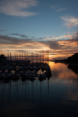 Yachts in harbor with sunset and cloudsの写真素材