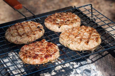 Four Hamburgers on Barbeque Grillの写真素材