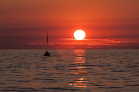 Sailing boats on a background of a beautiful sunsetの写真素材