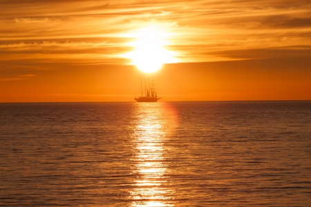 Sail ship silhouette at sea. Sun sunset on fireの写真素材