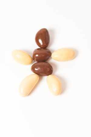 almonds in chocolate over white backgroundの写真素材