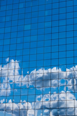 reflecting sky in glass of office building abstract backgroundの写真素材