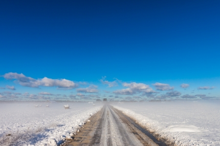 snowy road in coutryside with fogy horizonの写真素材