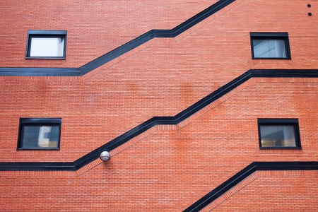 Old orange brick wall with four windows and street lampの写真素材