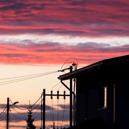 A fantastic sunset lights up the clouds above an urban streetの写真素材