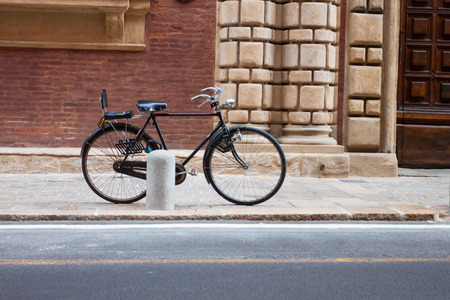 Italian old-style bicycles leaning against a wall in the historic centre  of Bolognaの写真素材