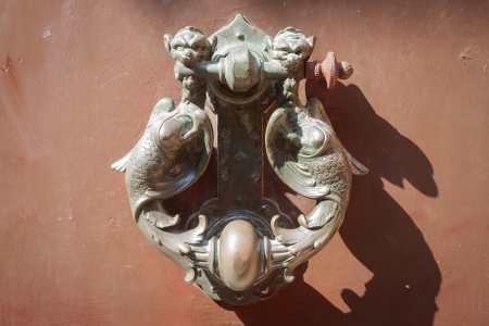 Old medieval metal handles on antique dark wooden doorの写真素材
