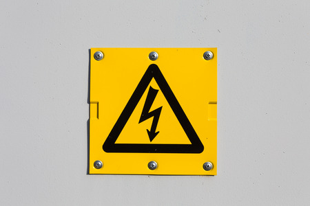 Sign of danger high voltage symbol on the white wallの写真素材