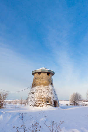 Estonian truncated windmill, a house and snowの写真素材