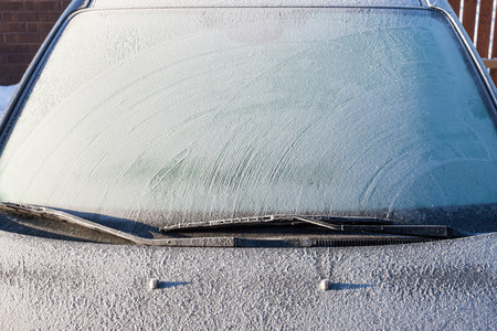 Snow covered car windshield - winter imageの写真素材