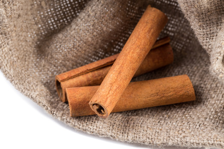 cinnamon sticks on hessian canvas with white backgroundの写真素材