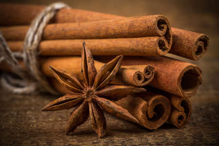 Close up of cinnamon sticks and star anise on rustic wood backgroundの写真素材