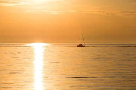 yacht silhouette in sunset light in seaの写真素材