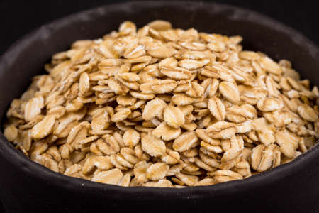 oat flakes in a bowl on dark board