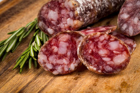 slices of salami on a wood board as a backgroundの写真素材