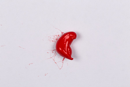 Red paint splash on a white paperの写真素材