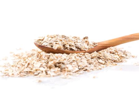 Whole grain, rolled oats flakes with wooden spoon