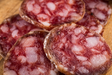slices of salami on a wood board as a backgroundの写真素材