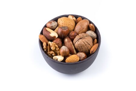 Large diversity of healthy nuts in a dark stone bowl - isolatedの写真素材