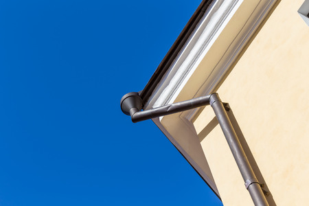 Rain gutters on old home. There is a blue sky in the background.