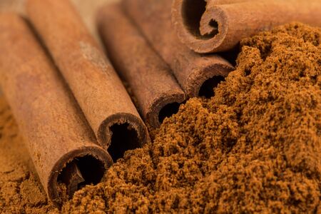 Cinnamon sticks with cinnamon powder on wooden backgroundの写真素材