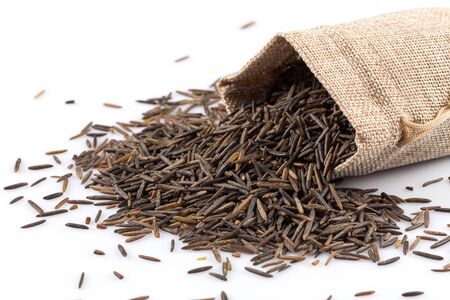 Close up image of a heap of wild rice on white background in a hessian sack