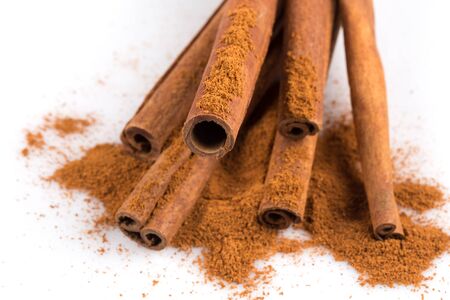 cinnamon sticks with powder isolated on white background