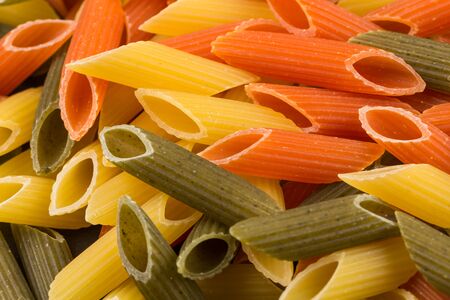 Color penne pasta. Tomato, spinach and wheat pastas in horizontal formatの写真素材