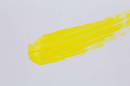 Yellow paint on white paper for background textureの写真素材