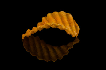 Potato chip on black surface closeup reflection detailの写真素材