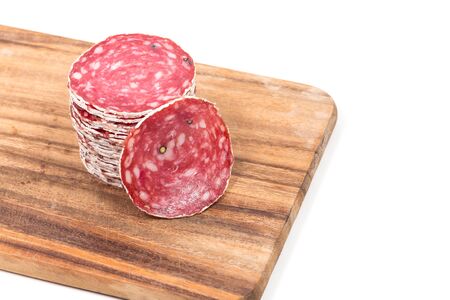 Slices of salami sausages on wooden board isolated