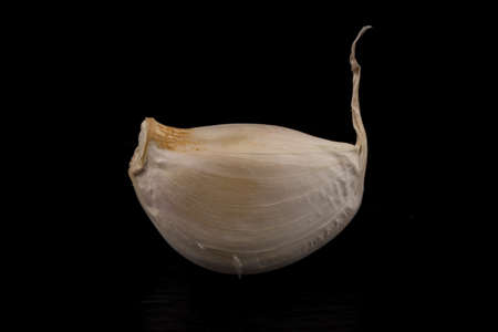 Garlic bulb closeup isolated on dark stone backgroundの写真素材