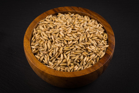 natural oat grains in bowl for background, close up shot