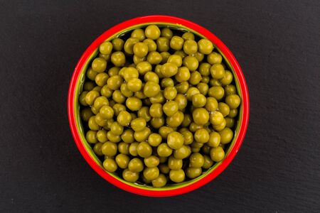 Marinated green peas in bowl on dark stone backgroundの写真素材