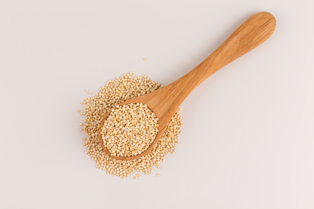 Pile of grain quinoa seeds in spoon isolated over the white backgroundの写真素材