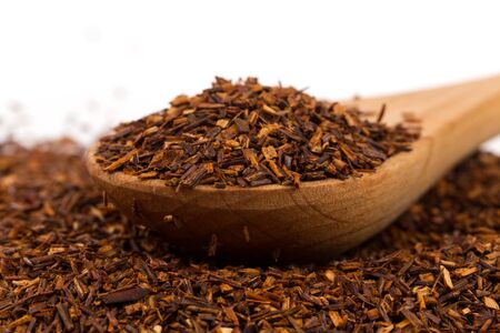 Heap of red dry rooibos healthy traditional organic tea in spoon on white isolated backgroundの写真素材