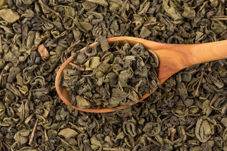 Gunpowder green tea in spoon closeup photo for backgroundの写真素材